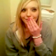 Two girls video record themselves peeing in a toilet.
